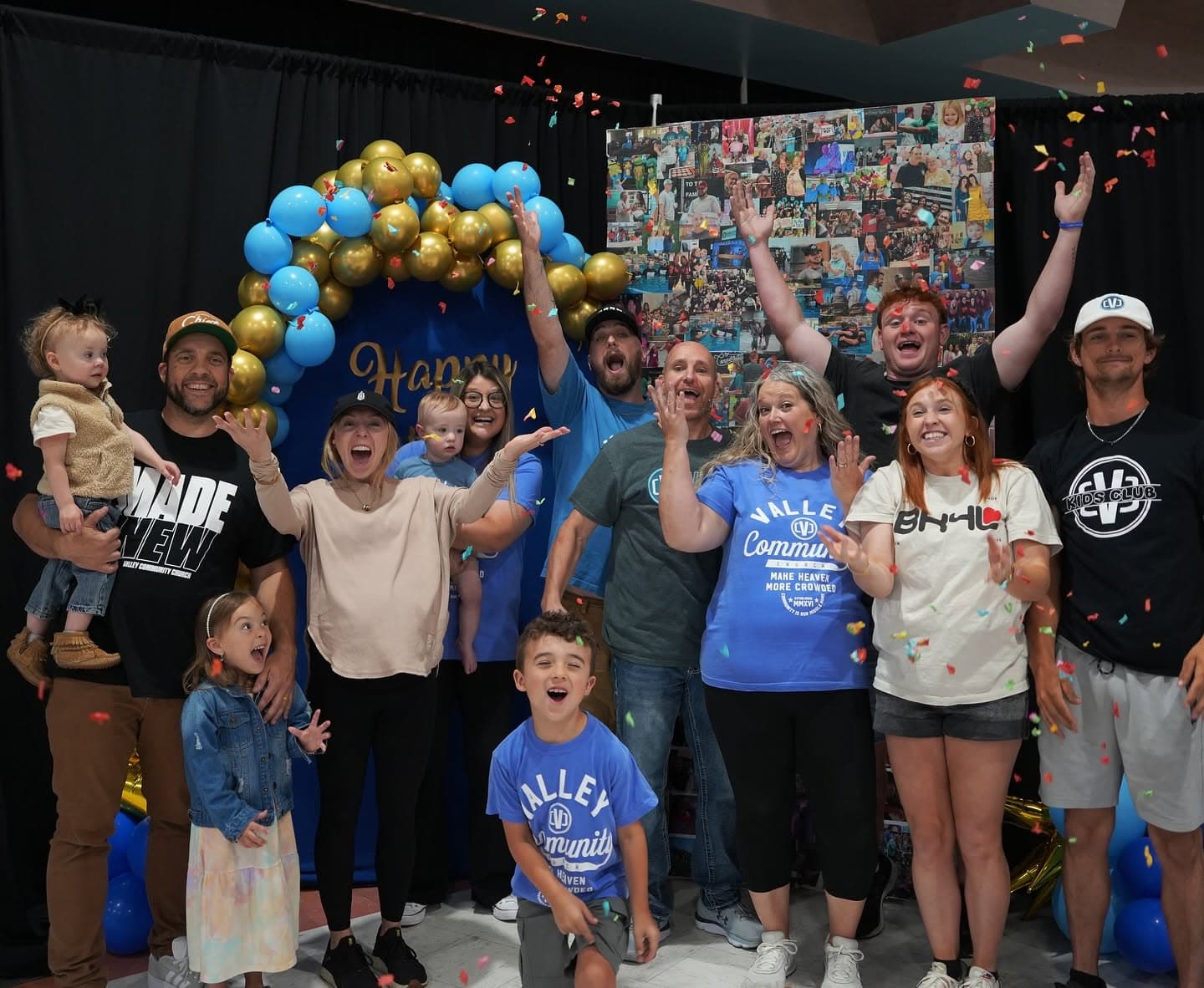 A dozen people of all ages from the church cheering together under falling confetti