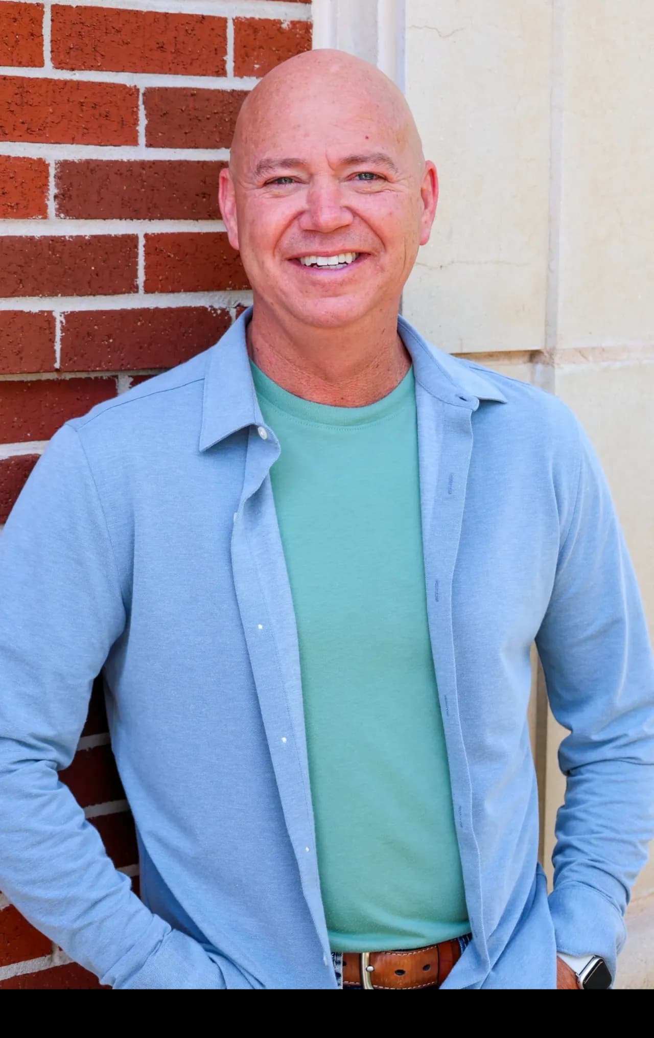 Dr. Josh Williams smiling, standing against a brick wall
