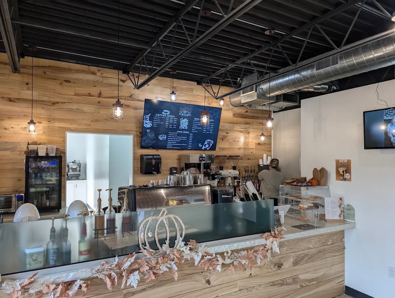 The counter at Valley Coffee Co, menu board above and someone working behind it