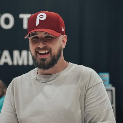 Pastor Caleb Spengler in a red ball cap, laughing