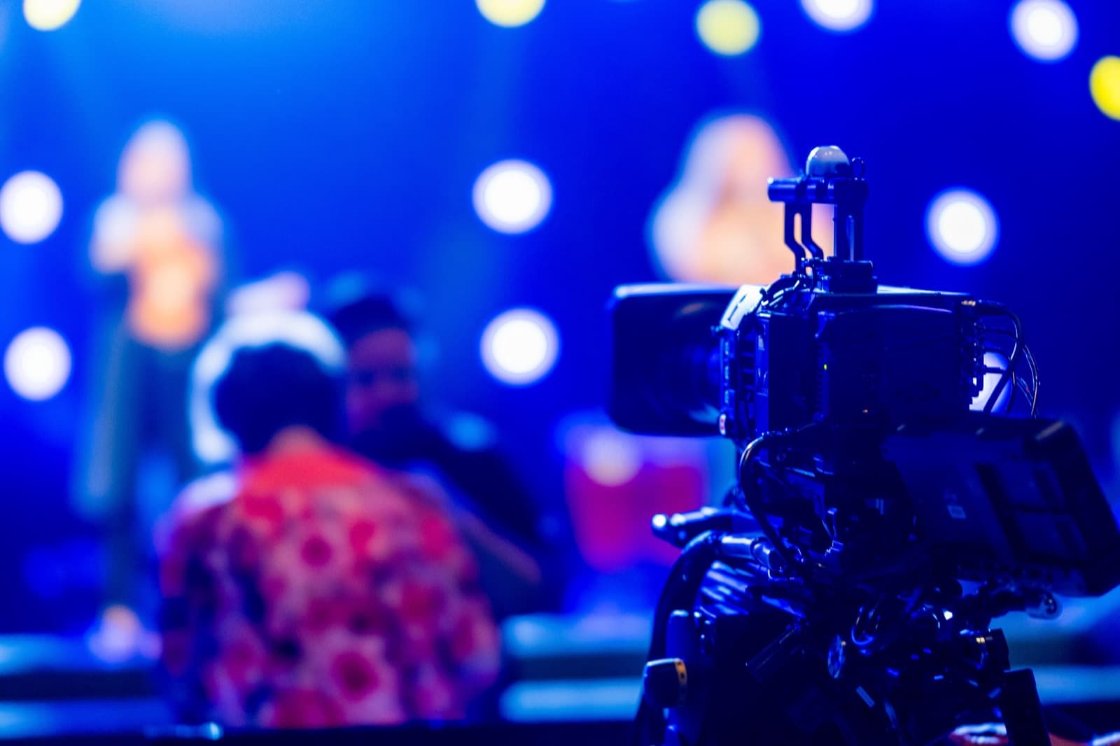 A camera operator in a headset filming the service for the online stream